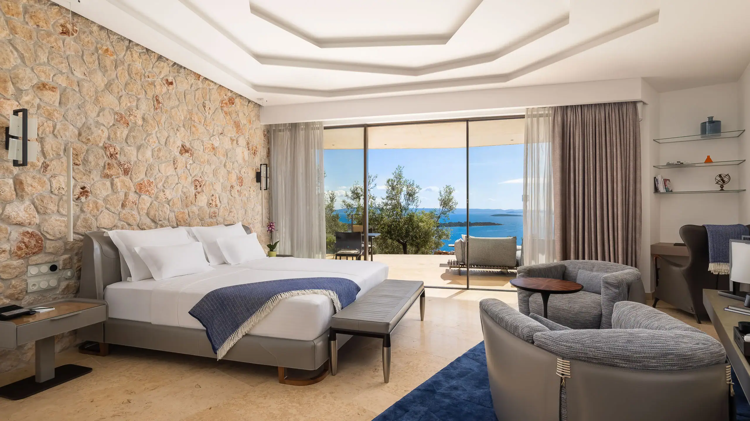 Elegant hotel bedroom with sea view, modern decor, and spacious balcony.